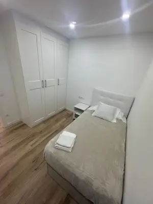 a white bedroom with a bed with two towels on it at Apartamento Plaza España - Bordeta BCN in Barcelona