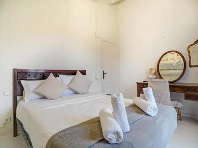 a bedroom with a bed with white towels on it at Masia Las Torres by Hello Homes Sitges in Sitges