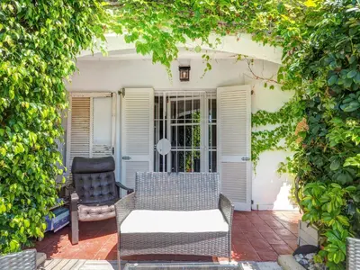 a patio with a couch and a chair on a patio at Masia Las Torres by Hello Homes Sitges in Sitges