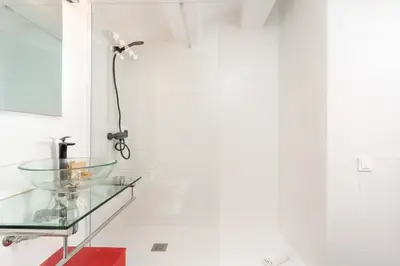 a bathroom with a glass sink and a lamp at Dúplex Deluxe Apartment in Badalona