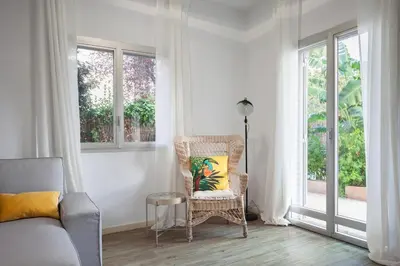a living room with a chair and a window at Marina beach Castelldefels in Castelldefels
