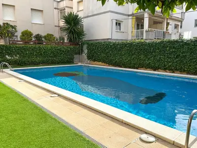 a large blue swimming pool in front of a building at Apartment Rivel in Cubelles