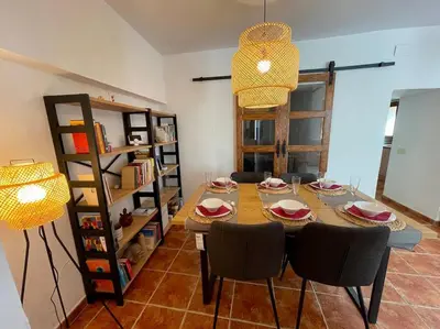 a dining room with a table and chairs and a shelf at Ca la Neus - Casa per 8 persones al poble de Mura in Mura