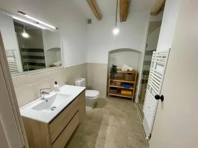 a bathroom with a sink and a toilet and a mirror at Ca la Neus - Casa per 8 persones al poble de Mura in Mura
