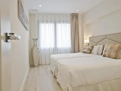 a white bedroom with a large bed and a window at Sitges Spaces Urban Beach Flat- 3 Bedrooms, 3 Bathrooms, Huge Terrace, Near Beach in Sitges