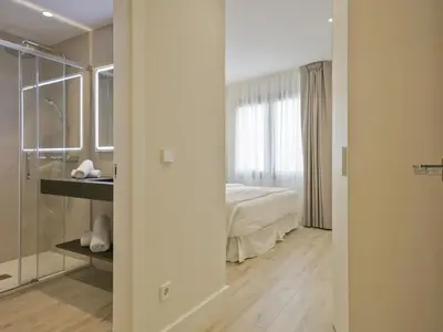 a bedroom with a bed and a sink and a mirror at Sitges Spaces Urban Beach Flat- 3 Bedrooms, 3 Bathrooms, Huge Terrace, Near Beach in Sitges