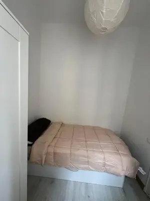 a bedroom with a bed with a pink blanket at Room Montjuic in Barcelona