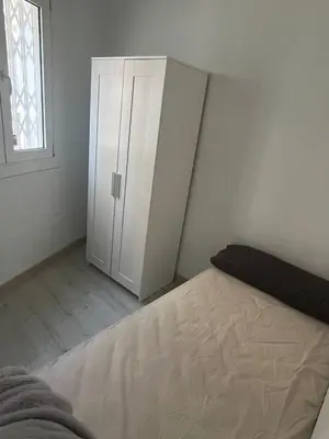 a bedroom with a white cabinet and a bed at Room Montjuic in Barcelona