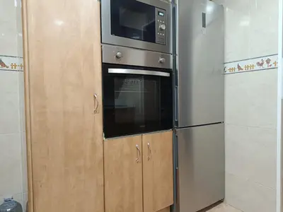 a kitchen with a microwave and a refrigerator at Habitación y baño privado in Vilanova del Camí