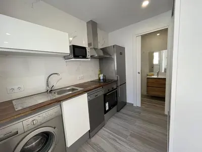 a kitchen with a sink and a washing machine at Beautiful renovated studio in Castelldefels