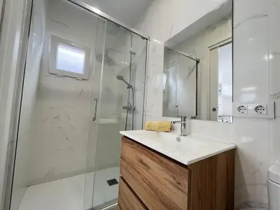 a bathroom with a shower and a sink and a mirror at Beautiful renovated studio in Castelldefels
