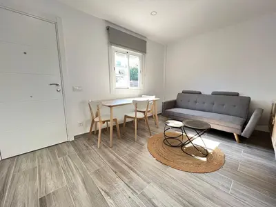a living room with a couch and a table and chairs at Beautiful renovated studio in Castelldefels