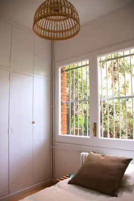 a bedroom with a bed and two windows at VILLA Mar y Montaña in Castelldefels