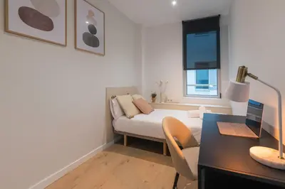 a bedroom with a bed and a desk with a laptop at CATERINA Bac de Roda in Barcelona