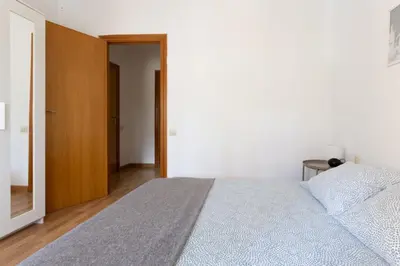 a bedroom with a large bed and a wooden door at Apartamento en castelldefels in Castelldefels