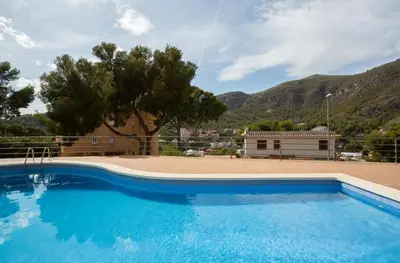 a large blue swimming pool in front of a house at Apartamento en castelldefels in Castelldefels