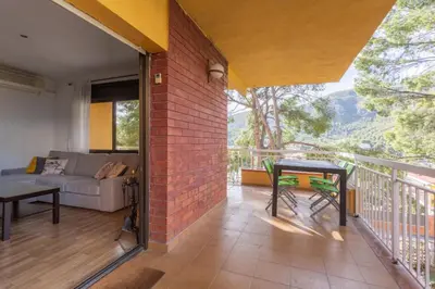 a living room with a couch and a table on a balcony at Apartamento en castelldefels in Castelldefels