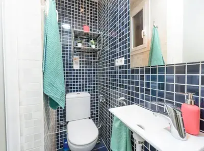 a blue tiled bathroom with a toilet and a sink at Ramblas Rentals Spacious & Design 4Br Flat With Balcony 15m Ramblas in Barcelona
