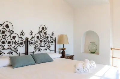 a bedroom with a bed with a black and white headboard at El Mirador Esencia Mediterránea in Arenys de Mar
