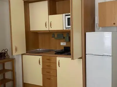 a kitchen with white cabinets and a white refrigerator at Piso Riera in Barcelona