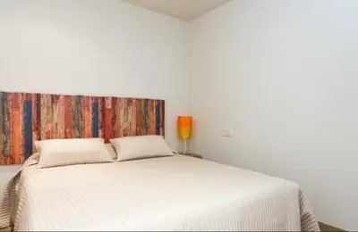 a white bed in a white room with a large bed at Rustic Casita Gavà in Barcelona