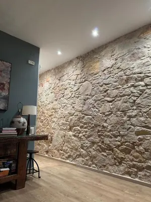 a stone wall in a room with a desk at Rustic Casita Gavà in Barcelona
