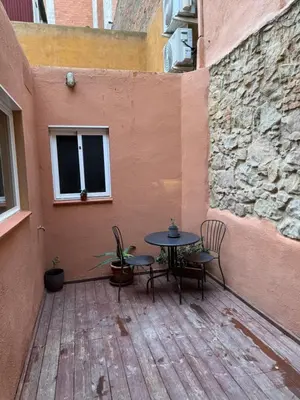 a patio with a table and chairs and a window at Rustic Casita Gavà in Barcelona
