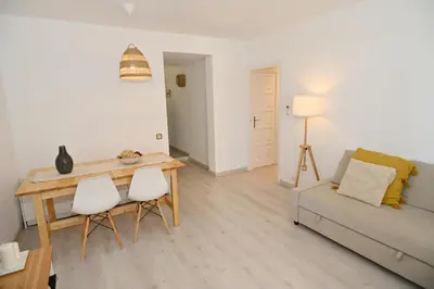 a living room with a couch and a table and chairs at Apartamento con piscina en Sant Pol de Mar in San Pol de Mar