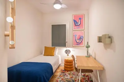 a small bedroom with a bed and a table at Spacious and elegant oasis in the best location, Eixample Barcelona in Barcelona