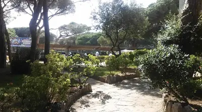a park with a bench and some bushes and trees at Bright Apartment In Gava Mar in Gavà