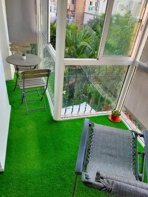 a room with a table and a bench and green grass at Vilamari 33 - 2 bedroom apartment in Barcelona