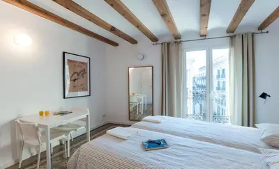 a bedroom with two beds and a desk and a window at Central Azulete in Barcelona