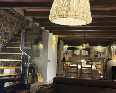 a living room with a couch and a table and a guitar at Ca l'Esclatat in Santa María de Palautordera