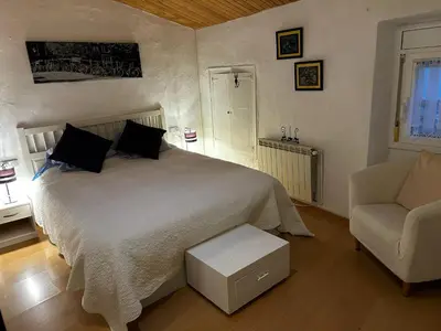 a bedroom with a bed and a couch and a chair at Casa Añeja in Collbató