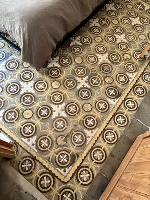 a floor with a bed with a rug on it at Cozy Suite in a historic house near the sea in Vilanova i la Geltrú