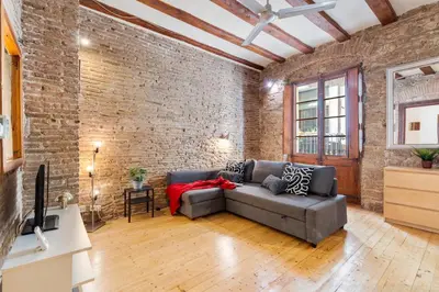 a living room with a couch and a brick wall at Historic El Born 2BR Monthly Stay Workspace in Barcelona