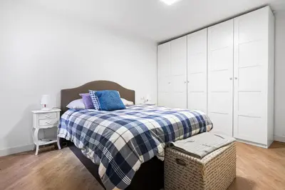 a bedroom with a bed with a blue and white blanket at 55m² Monthly Base w Terrace AC in Barcelona