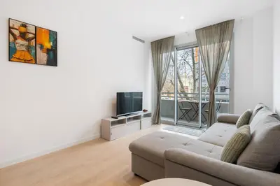 a living room with a couch and a tv at Diagonal Mar Monthly 2BR Pools Parking in Barcelona