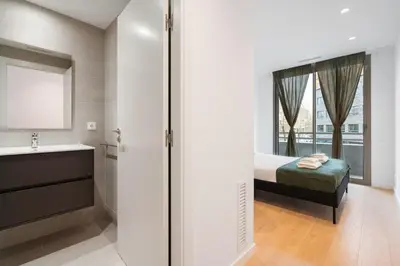 a bedroom with a bed and a sink and a mirror at Diagonal Mar Monthly 2BR Pools Parking in Barcelona
