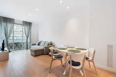 a living room with a table and chairs and a couch at Diagonal Mar Monthly 2BR Pools Parking in Barcelona