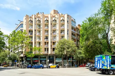 a large building with cars parked in front of it at 5BR for 7 Elevator Walk to Sant Antoni in Barcelona