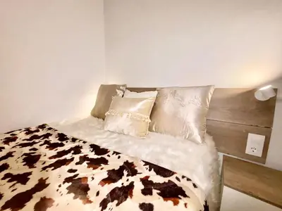 a bed with a black and white blanket and pillows at Piso en gracia de 3 habitaciones dobles suits in Barcelona