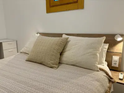a bed with white sheets and pillows on it at Piso en gracia de 3 habitaciones dobles suits in Barcelona