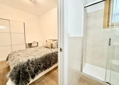 a bedroom with a bed and a glass shower at Piso en gracia de 3 habitaciones dobles suits in Barcelona