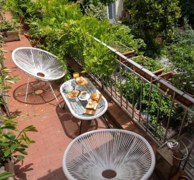 a table with food and two chairs on a balcony at Piso en gracia de 3 habitaciones dobles suits in Barcelona