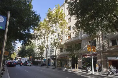a city street with a building and cars on the road at Céntrico apartamento in Barcelona