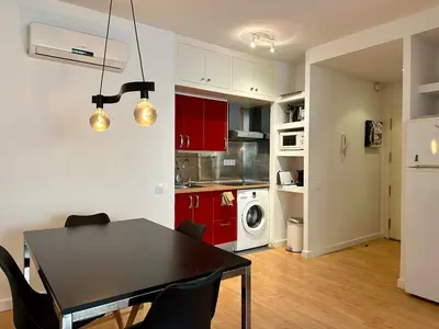 a kitchen and dining room with a black table and chairs at Spacious 1 bedroom home in Bonanova in Barcelona