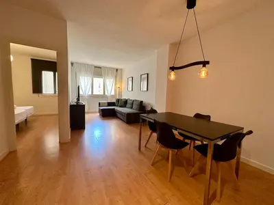 a living room with a table and a couch at Spacious 1 bedroom home in Bonanova in Barcelona