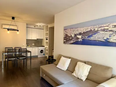 a living room and kitchen with a couch and a table at Spacious 1 br home in Bonanova in Barcelona