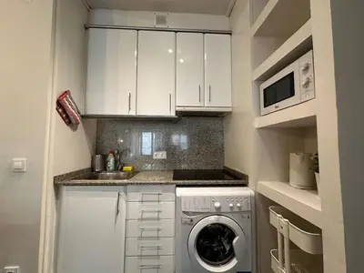 a small kitchen with a washing machine in it at Spacious 1 br home in Bonanova in Barcelona